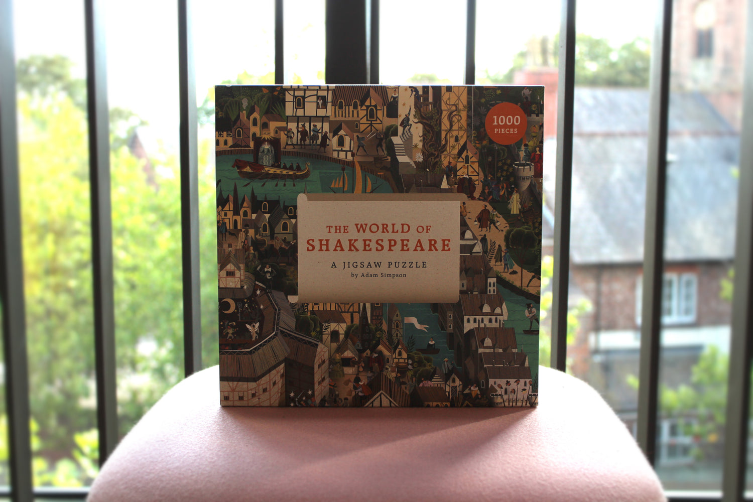The World of Shakespeare jigsaw box with a window behind showing a backdrop of some greenery.