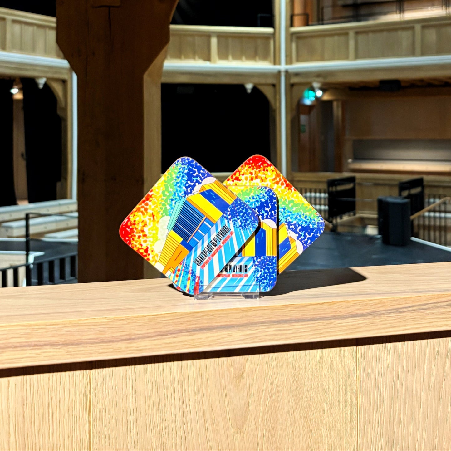 Three coasters, each featuring a rainbow illustration of the Shakespeare North building.