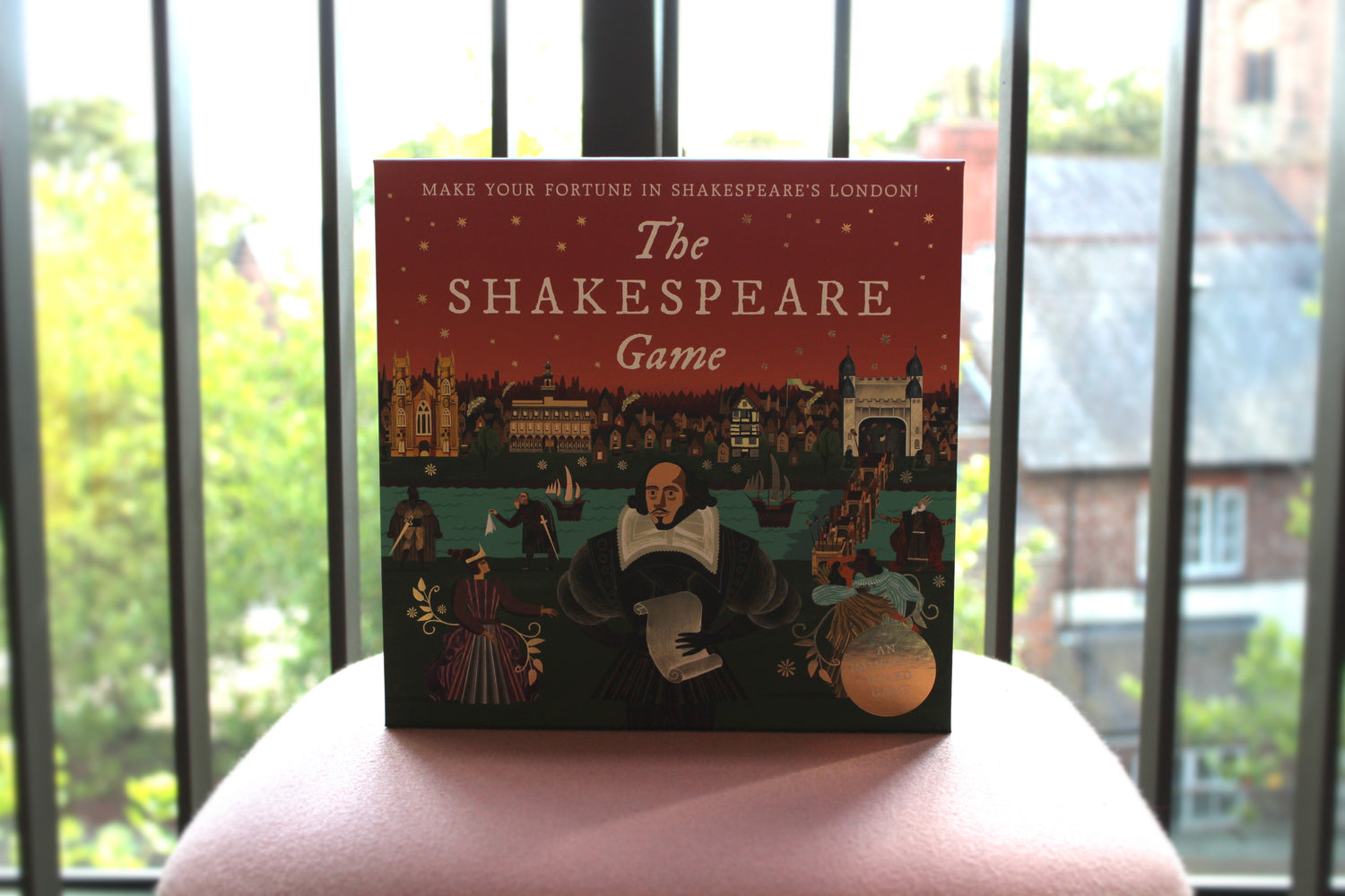 The Shakespeare Game box with a window behind showing a backdrop of some greenery.