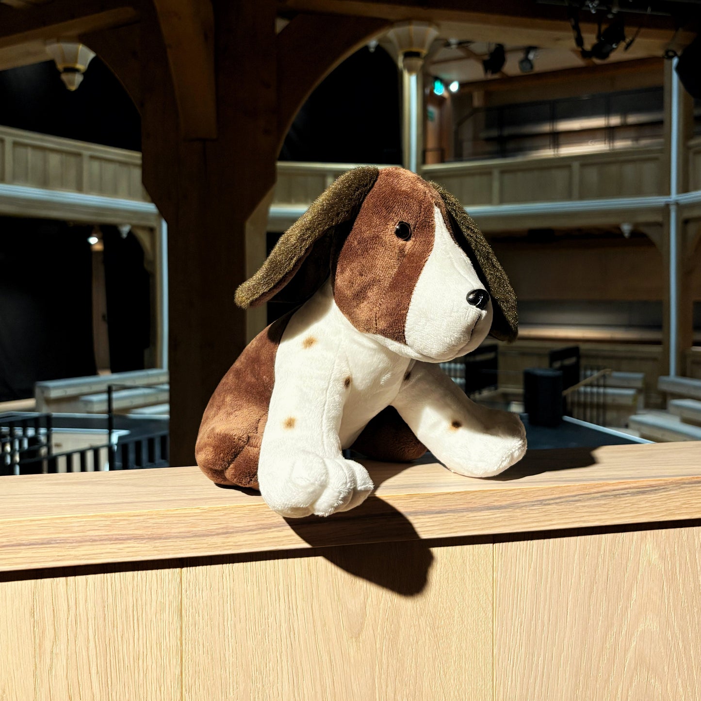 Plush dog toy on a wooden ledge.